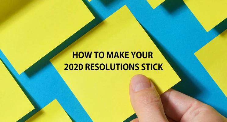 Hand holding a yellow sticky note, with the text How to Make Your 2020 Resolutions Stick