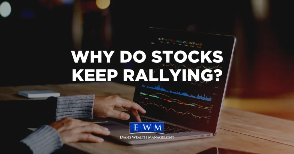 Hands on a laptop showing stock charts, with the text Why Do Stocks Keep Rallying? and the Evans Wealth Management logo