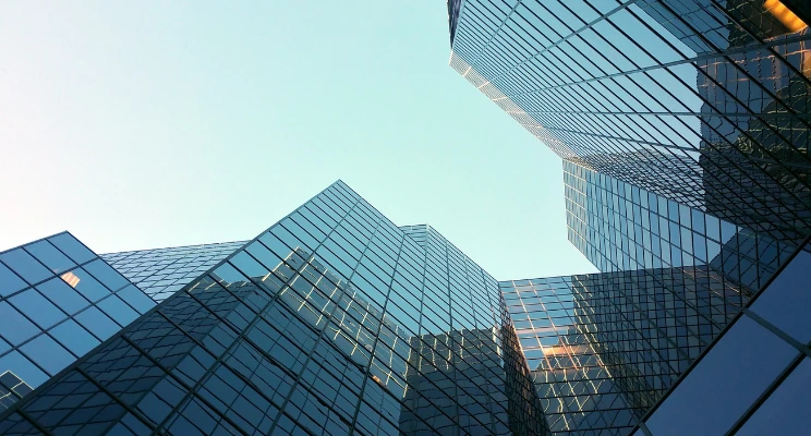 Glass office towers seen from below against the sky